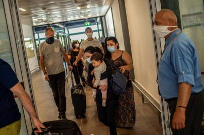 Passengers of a flight from Frankfurt wearing protective face masks arrive at the Corfu Airport Ioannis Kapodistrias on Corfu Island on July 1, 2020, on its reopening day following months of closure due to the sanitary measures taken to curb the spread of the Covid-19 disease caused by the novel coronavirus. - Greece on July 1, 2020 reopened flights to its flagship island destinations as it raced to salvage a portion of the annual tourism season that is vital to its economy. (Photo by ANGELOS TZORTZINIS / AFP)<!-- NICAID(14534877) -->