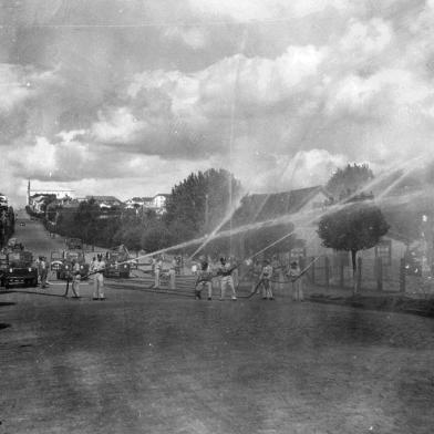 Demonstração de combate ao fogo pelos bombeiros na Rua Sinimbu em direção a Coronel Flores, onde ficava a antiga sede, por volta de 1958. Local é em frente ao Colégio São Carlos<!-- NICAID(14537741) -->