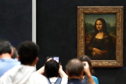 Visitors wearing face masks take pictures in front of Leonardo da Vincis masterpiece   Mona Lisa  also known as  La Gioconda   held in the Salle des  Etats, at the Louvre Museum in Paris on July 6, 2020, on the museum s reopening day. - The Louvre museum will reopen its doors on July 6, 2020, after months of closure due to lockdown measures linked to the COVID-19 pandemic, caused by the novel coronavirus. The coronavirus crisis has already caused more than 40 million euros in losses at the Louvre, announced its president and director Jean-Luc Martinez, who advocates a revival through cultural democratization and is preparing a transformation plan for the upcoming Olympic Games in 2024. (Photo by FRANCOIS GUILLOT / AFP)<!-- NICAID(14538747) -->