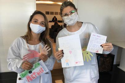 A tarde desta sexta-feira (03/07) foi recheada de emoção e solidariedade. Isso porque a equipe da Rede de Ensino Caminho do Saber entregou as quase 600 cartas que foram escritas pelos estudantes para os profissionais de saúde de Caxias do Sul. Na foto, as fisioterapeutas do Hospital do Círculo Sheila Müller (E) e Daniela De Gaspery, com as cartas que receberam.<!-- NICAID(14542295) -->