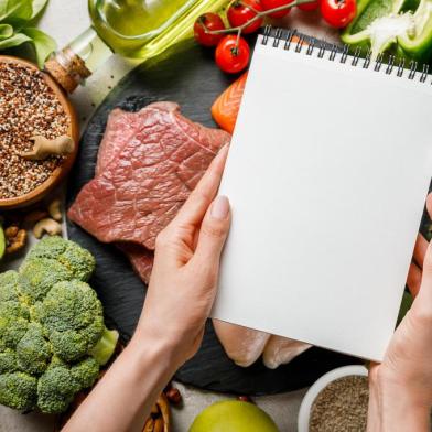 cropped view of woman holding empty notebook above food for ketogenic diet menuPORTO ALEGRE, RS, BRASIL, 25/06/2019- Alimentação saudavel. Dieta. vegetais. verduras. (Foto: LIGHTFIELD STUDIOS  / stock.adobe.com)Fonte: 279814188<!-- NICAID(14439373) -->