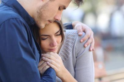  Man comforting his sad mourning friend embracing her in a parkFonte: 90397080<!-- NICAID(14353141) -->