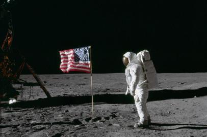 AS11-40-5875 (20 July 1969) --- Astronaut Edwin E. Aldrin Jr., lunar module pilot of the first lunar landing mission, poses for a photograph beside the deployed United States flag during an Apollo 11 extravehicular activity (EVA) on the lunar surface. The Lunar Module (LM) is on the left, and the footprints of the astronauts are clearly visible in the soil of the moon. Astronaut Neil A. Armstrong, commander, took this picture with a 70mm Hasselblad lunar surface camera. While astronauts Armstrong and Aldrin descended in the LM, the Eagle, to explore the Sea of Tranquility region of the moon, astronaut Michael Collins, command module pilot, remained with the Command and Service Modules (CSM) Columbia in lunar orbit. Photo credit: NASAO astronauta Edwin E. Aldrin Jr., piloto do módulo lunar da primeira missão de pouso lunar, posa para uma fotografia ao lado da bandeira dos Estados Unidos durante uma atividade extraveicular da Apollo 11 (EVA) na superfície lunar.APOLLO 11 ONBOARD PHOTO: GOOD VIEW OF ASTRONAUT FOOTPRINT IN LUNAR SOIL.<!-- NICAID(14172266) -->