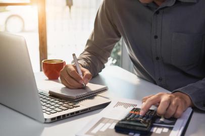  Male businessman working on desk office with using a calculator to calculate the numbers, finance accounting concept.Fonte: 294105357<!-- NICAID(14530970) -->