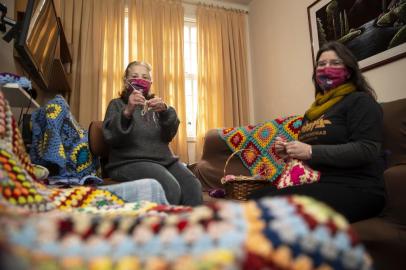  PORTO ALEGRE, RS, BRASIL - 17.07.2020 - Voluntárias confeccionam quadradinhos de tricô e crochê que viram mantas, doadas para asilos e entidades sociais. É o projeto Fios que Aquecem em Quadradinhos. Nas imagens a voluntária Mine e Patrícia (de preto). (Foto: Jefferson Botega/Agencia RBS)Indexador: Jeff Botega