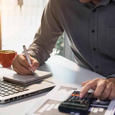  Male businessman working on desk office with using a calculator to calculate the numbers, finance accounting concept.Fonte: 294105357<!-- NICAID(14530970) -->