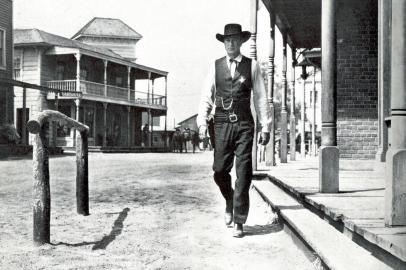 MATAR OU MORRER (High Noon) - De Fred Zinemann. Com Gary Cooper e Grace Kelly. Muito antes de Jack Bauer, um herói do Velho Oeste encarou uma tensa corrida contra o relógio acompanhada em tempo real pelo espectador. O xerife Will Kane está prestes a se casar com uma bela garota, e tudo parece calmo na cidadezinha naquele domingo. Até chegar a notícia de que um pistoleiro que Kane mandou para a prisão foi solto e está para chegar no trem do meio-dia. O desejo do vilão é acertar as contas com o xerife e assumir o controle do lugar com seus capangas. Mas Kane não é de fugir da raia, mesmo que todo mundo ali lhe deixe na mão por acreditar que ele não tem chance e, se não der o fora, já é um homem morto. Faroeste, EUA, 1952. TCM, 14h.<!-- NICAID(8183669) -->