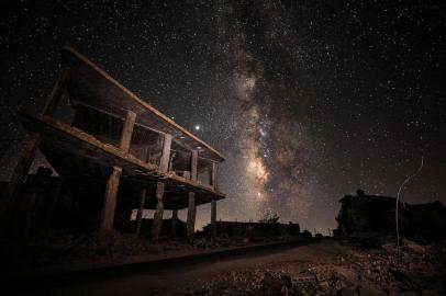  This long-exposure picture taken early on July 21, 2020, shows a view of the Milky Way galaxy rising in the sky above destroyed buildings in the village of Balyun in the rebel-held southern countryside of Syrias northwestern province of Idlib, near the frontline with government forces. (Photo by Omar HAJ KADOUR / AFP)Editoria: SCILocal: BalyunIndexador: OMAR HAJ KADOURSecao: natural scienceFonte: AFPFotógrafo: STR<!-- NICAID(14551909) -->