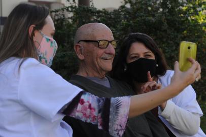  CAXIAS DO SUL, RS, BRASIL, 23/07/2020 - No Dias dos Avós, mostramos como os idosos encaram a ausência dos netos durante a pandemia e como as chamadas de vídeo se tornaram uma forma de amenizar a saudade. No Lar da Velhice São Francisco de Assis, o uso da tecnologia rende momentos de emoção e felicidade para os velhinhos. NA FOTO: com auxilio de suas cuidadoras Vanessa e Rejane, Seu Levi conversa com os netos por vídeo chamada. (Marcelo Casagrande/Agência RBS)<!-- NICAID(14551987) -->