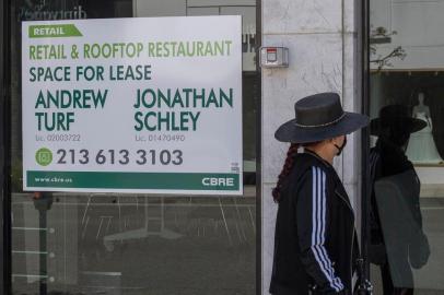 (FILES) In this file a woman walks past empty stores and restaurants closed due to impact of the Coronavirus (Covid-19) in Beverly Hills, California on May 8, 2020. - The US economy collapsed in the midst of the coronavirus pandemic in the April-to-June period, contracting 32.9 percent in the second quarter, the government reported on July 30, 2020. The decline, though slightly less bad than expected, was the worst on record for the worlds largest economy, dating back to 1947. However, the Commerce Department figures are an annual rate so not comparable to the quarterly contractions reported in other advanced economies. (Photo by Mark RALSTON / AFP)<!-- NICAID(14556650) -->