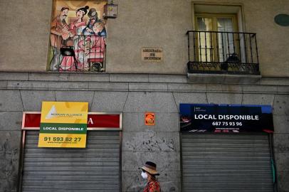 (FILES) In this file photo taken on July 9, 2020 a woman walks past closed shops in Madrid. - In Spain, the coronavirus has pushed small businesses to the brink of collapse. So far, 40,000 bars, restaurants and hotels have permanently closed, with the figure seen rising to 65,000 by the end of the year -- or 20 percent of the total, Spains hostelry federation says. (Photo by Gabriel BOUYS / AFP)<!-- NICAID(14558185) -->