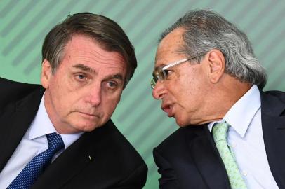  Brazilian President Jair Bolsonaro (L) listens to his Economy Minister Paulo Guedes during a ceremony to sanction of a law that will offer lower bank rates for people who do not have debts, at Planalto Palace in Brasilia, on January 12,  2019. - Brazilian President Jair Bolsonaro on Monday sacked his education minister, an ultraconservative who had drawn public ire over a range of controversial proposals including a revision of school textbooks to deny the 1964 military coup. (Photo by EVARISTO SA / AFP)Editoria: POLLocal: BrasíliaIndexador: EVARISTO SASecao: politics (general)Fonte: AFPFotógrafo: STF<!-- NICAID(14037705) -->