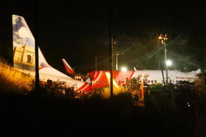 First responders inspect the wreckage of an Air India Express jet, which was carrying more than 190 passengers and crew from Dubai, after it crashed by overshooting the runway at Calicut International Airport in Karipur, Kerala, on August 7, 2020. - At least 14 people died and 15 others were critically injured when a passenger jet skidded off the runway after landing in heavy rain in India, police said on August 7. (Photo by Favas JALLA / AFP)<!-- NICAID(14563250) -->