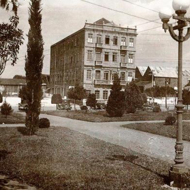 Rua Marquês do Herval captada a partir da Praça Dante Alighieri por volta de 1931. Vê-se o antigo Grande Hotel Mimoso, anteriormente Hotel Veiga e posteriormente o novo Hotel Menegotto. À esquerda, o terreno vazio que abrigaria o Cine Guarany e, à direita, na esquina, a Casa Minghelli, destruída por um incêndio em 1952.<!-- NICAID(14566199) -->