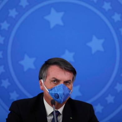 Brazils President Jair Bolsonaro wears a face mask during a press conference on the coronavirus pandemic COVID-19 at the Planalto Palace in Brasilia, Brazil on March 20, 2020. - Brazils government on Friday drastically downgraded its growth projections for 2020 by 2.1 percent to practically zero (0.02 percent) due to the coronavirus pandemic. (Photo by Sergio LIMA / AFP)<!-- NICAID(14461916) -->