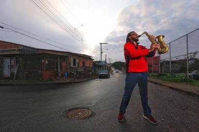 >> FOTOS EM BAIXA << Quando morou na Vila Safira, há uma década, o maestro Hélder Corrêa viveu o pior que a música pôde proporcionar nos seus 43 anos de vida. A instabilidade financeira da profissão levou o saxofonista a se abrigar na casa de amigos, em uma das regiões mais vulneráveis do bairro Mario Quintana, zona norte de Porto Alegre.Os shows voltaram, o artista retomou o equilíbrio financeiro, mas a realidade do local que o acolheu seguiu a mesma. A partir de um projeto tocado a muitas mãos, ele espera que isso seja reduzido, ao menos um pouco.Desde março, ao lado de outros voluntários, em um terreno doado e com o dinheiro das apresentações investido, uma padaria nasce na região, com intuito de gerar empregos e profissionalizar a comunidade.<!-- NICAID(14567658) -->