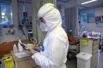  A health worker makes a report as a patient infected with COVID-19 is treated at the Intensive Care Unit of the Santa Casa de Misericordia Hospital in Porto Alegre, Brazil, on August 13, 2020. - The occupancy of ICU beds by COVID-19 patients has risen and reached the highest mark since the beginning of the pandemic in Porto Alegre, where only a 9.4% of UCI beds remain empty. (Photo by SILVIO AVILA / AFP)Editoria: HTHLocal: Porto AlegreIndexador: SILVIO AVILASecao: diseaseFonte: AFPFotógrafo: STR<!-- NICAID(14570351) -->