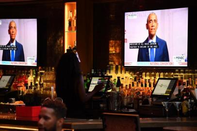 Former US President Barack Obama is seen on television screens as he speaks during the third day of the Democratic National Convention, being held virtually amid the novel coronavirus pandemic, at The Abbey bar and restaurant in West Hollywood, California, August 19, 2020. (Photo by Robyn Beck / AFP)