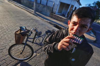 >> FOTOS EM BAIXA <<A bicicleta de três aros chama atenção pela parafernália atrelada ao quadro. Os olhares mais atentos logo veem que a roda de menor diâmetro, afixada aos raios, fora instalada como uma polia que transfere a força do pedal para a correia de borracha - sistema construído para mover duas pedras de esmeril com espessura distinta.Toda engenhoca é tocada diariamente por Mateus Dorneles da Silva, 23 anos, amolador de facas desde os 15. O jovem segue a profissão ensinada pelo irmão mais velho, que também atua nas ruas, hoje apenas aos finais de semana. Com parte da população isolada em casa, imposição da pandemia de coronavírus, eles dizem ter dobrado o número de atendimentos em Porto Alegre.<!-- NICAID(14574964) -->