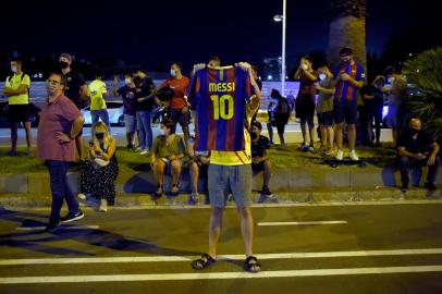  FC Barcelona supporters gather outside the clubs headquarters in Barcelona, on August 25, 2020, following the announcement of Argentinian player Lionel Messis desire to leave the team. - Lionel Messi has informed Barcelona he wants to unilaterally terminate his contract with the Spanish giants, a club source confirmed to AFP today. Lawyers for the Argentina star sent Barca a fax in which they announced Messis desire to rescind his contract by triggering a release clause, sending shockwaves throughout the world of football. (Photo by Pau BARRENA / AFP)Editoria: SPOLocal: BarcelonaIndexador: PAU BARRENASecao: soccerFonte: AFPFotógrafo: STR<!-- NICAID(14576340) -->