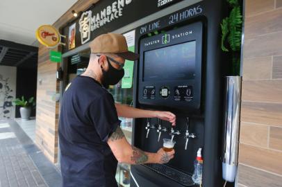  PORTO ALEGRE, RS, BRASIL, 01-09-2020: O bar Mambembe Brewplace instalou um sistema de self service de cerveja com torneiras voltadas par ao lado de fora. A pessoa compra créditos pelo app e abastece sozinha ali. Na foto, Alessandro Siais, proprietário do bar, mostra o funcionamento (FOTO FÉLIX ZUCCO/AGÊNCIA RBS, Editoria de SuaVida).<!-- NICAID(14581529) -->