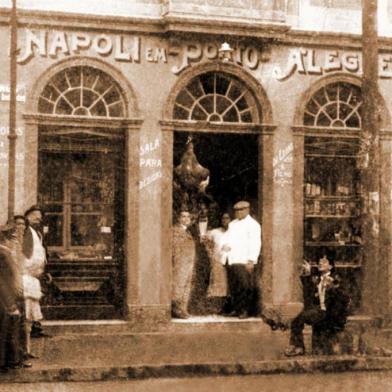  Os calabrêses Nicola di Leone (de branco) e seu filho Natale (à esquerda na porta) na casa comercial Napoli em Porto Alegre, que mantinham na esquina da Rua dos Andradas com a Rua Clara (atual João Manoel), no início do século passado.<!-- NICAID(14582520) -->