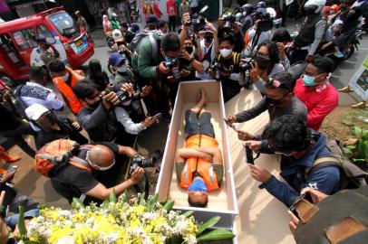  A man, caught not wearing a face mask in public amid the COVID-19 coronavirus pandemic, lies in a mock coffin while members of the public and the media take pictures as part of punishment by local authorities and enforced by local police, in Jakarta, on September 3, 2020. (Photo by FAHMI DOLLI / AFP)Editoria: HTHLocal: JakartaIndexador: FAHMI DOLLISecao: epidemic and plagueFonte: AFPFotógrafo: STR<!-- NICAID(14583466) -->