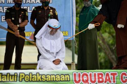  A woman (C) reacts as she receives 100 whippings as punishment for pre-marital sex, in front of Al Munawarah mosque in Jantho, Aceh province on September 4, 2020. - Aceh is the only region in Muslim-majority Indonesia to impose Islamic law, which allows whipping for a range of charges. (Photo by CHAIDEER MAHYUDDIN / AFP)Editoria: RELLocal: JanthoIndexador: CHAIDEER MAHYUDDINSecao: punishmentFonte: AFPFotógrafo: STR<!-- NICAID(14584388) -->