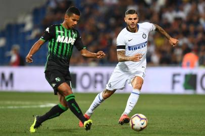  Sassuolos Brazilian defender Rogerio (L) passes the ball past Inter Milans Argentine forward Mauro Icardi during the Italian Serie A football match Sassuolo vs Inter Milan at the Mapei Stadium in Reggio Emilia on August 19, 2018. (Photo by Vincenzo PINTO / AFP)Editoria: SPOLocal: Reggio EmiliaIndexador: VINCENZO PINTOSecao: soccerFonte: AFPFotógrafo: STF<!-- NICAID(14589213) -->