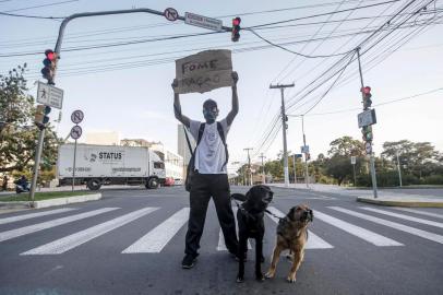  PORTO ALEGRE, RS, BRASIL - 27.08.2020 - Pandemia faz aumentar desigualdade social. Tornou-se mais comum ver pedintes nas sinaleiras. Na foto, Vagner de Oliveira Cardoso, com os cães Laica e Negão. (Foto: ANDRÉ ÁVILA/ Agência RBS)Indexador: Andre Avila<!-- NICAID(14578570) -->