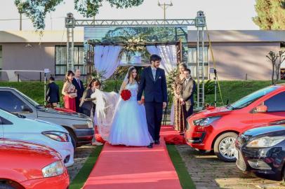 O noivo Leonardo Henrique Quinebre Alves, 26 anos, aguardava ansioso e sorridente, enquanto a noiva Liliane Stamm, 26, caminhava pelo tradicional tapete vermelho.  Elegante e graciosa, em um vestido branco estilo princesa, com corpete, e transpassado nas costas, de braços dados com o pai, ela seguiu em direção ao altar. O clima era agradável, em Lagoa Vermelha, naquele 20 de setembro de 2020 e a emoção tomou conta dos noivos e dos convidados. O casamento aconteceu de acordo com o planejado e seguiu o padrão de uma cerimônia tradicional ao ar livre, exceto por alguns detalhes marcantes: os 50 convidados assisitiram a cerimônia sem descer dos carros, não havia padrinhos e nem damas ou pajens para levar as alianças. O modelo drive-in foi a opção encontrada pelo casal para celebrar o amor perante Deus, familiares e amigos, em meio à pandemia de coronavírus. A união de Leonardo e Liliane entra para história como o primeiro casamento neste modelo celebrado no RS.<!-- NICAID(14601405) -->