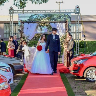 O noivo Leonardo Henrique Quinebre Alves, 26 anos, aguardava ansioso e sorridente, enquanto a noiva Liliane Stamm, 26, caminhava pelo tradicional tapete vermelho.  Elegante e graciosa, em um vestido branco estilo princesa, com corpete, e transpassado nas costas, de braços dados com o pai, ela seguiu em direção ao altar. O clima era agradável, em Lagoa Vermelha, naquele 20 de setembro de 2020 e a emoção tomou conta dos noivos e dos convidados. O casamento aconteceu de acordo com o planejado e seguiu o padrão de uma cerimônia tradicional ao ar livre, exceto por alguns detalhes marcantes: os 50 convidados assisitiram a cerimônia sem descer dos carros, não havia padrinhos e nem damas ou pajens para levar as alianças. O modelo drive-in foi a opção encontrada pelo casal para celebrar o amor perante Deus, familiares e amigos, em meio à pandemia de coronavírus. A união de Leonardo e Liliane entra para história como o primeiro casamento neste modelo celebrado no RS.<!-- NICAID(14601405) -->