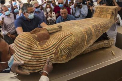 A picture taken on October 3, 2020 shows Egyptian Minister of Tourism and Antiquities Khaled Al-Anani (L), and Mustafa Waziri (R), Secretary General of the Supreme Council of Antiquities, open a sarcophagus excavated by the Egyptian archaeological mission working at the Saqqara necropolis, 30 kms south of the capital Cairo, which resulted in the discovery of a deep burial well with more than 59 human coffins closed for more than 2,500 years. - They were unearthed south of Cairo in the sprawling burial ground of Saqqara, the necropolis of the ancient Egyptian capital of Memphis, a UNESCO World Heritage site. Their exteriors are covered in intricate designs in vibrant colours as well as hieroglyphic pictorials. (Photo by Khaled DESOUKI / AFP)<!-- NICAID(14608497) -->