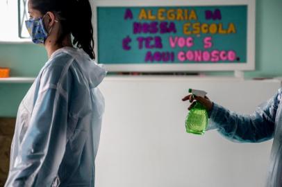  PORTO ALEGRE, RS, BRASIL - 05/10/2020Volta às aulas na Escola de Educação Infantil Neneca em meio a pandemia de coronavírus. Na foto, funcionárias limpam seus jalecos