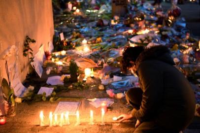 A child lights a candle at the entrance of a middle school in Conflans-Sainte-Honorine, 30kms northwest of Paris, on October 17, 2020, after a teacher was decapitated by an attacker who has been shot dead by policemen. - The man suspected of beheading on October 16 ,2020 a French teacher who had shown his students cartoons of the prophet Mohammed was an 18-year-old born in Moscow and originating from Russias southern region of Chechnya, a judicial source said on October 17. Five more people have been detained over the murder on October 16 ,2020 outside Paris, including the parents of a child at the school where the teacher was working, bringing to nine the total number currently under arrest, said the source, who asked not to be named. The attack happened at around 5 pm (1500 GMT) near a school in Conflans-Sainte-Honorine, a western suburb of the French capital. The man who was decapitated was a history teacher who had recently shown caricatures of the Prophet Mohammed in class. (Photo by Bertrand GUAY / AFP)<!-- NICAID(14619458) -->