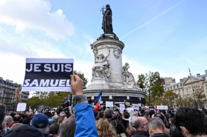 A person holds a placard reading I am Samuel as people gather on Place de la Republique in Paris on October 18, 2020, in homage to history teacher Samuel Paty two days after he was beheaded by an attacker who was shot dead by policemen. - Thousands of people rally in Paris and other French cities on October 18 in a show of solidarity and defiance after a teacher was beheaded for showing pupils cartoons of the Prophet Mohammed. His murder in a Paris suburb on October 16 shocked the country and brought back memories of a wave of Islamist violence in 2015. (Photo by BERTRAND GUAY / AFP)<!-- NICAID(14619613) -->