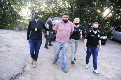  PORTO ALEGRE,RS,BRASIL.2020,10,18.Depois de muitas buscas,foi preso pela Polícia Civil,Rodrigo Camargo, 44 anos de idade,que já tem cinco condeções por estupros,condenado a 38 anos de prisão,e que vinha praticando desde 2013,ataques as mulheres com estupros,que atacava na rua e em lojas comerciais da  zona sul,de Porto Alegre,foi preso pella Policia na Vila Cruzeiro,em um estabelecimento comercial na fila do pão.Na foto.Preso Rodrigo Camargo sendo conduzido pelas as agentes.(RONALDO BERNARDI/AGENCIA RBS).<!-- NICAID(14619742) -->