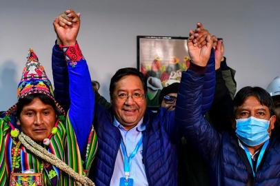 Bolivias leftist presidential candidate Luis Arce (C), of the Movement for Socialism party, celebrates with running mate David Choquehuanca (R) early on October 19, 2020, in La Paz, Bolivia. - Bolivian presidential candidate Luis Arce, the leftist heir to former leader Evo Morales, appeared headed to a first-round election victory on October 18, 2020 with 52.4 percent of the vote, according to an authoritative exit poll from TV station Unitel. (Photo by RONALDO SCHEMIDT / AFP)<!-- NICAID(14620368) -->