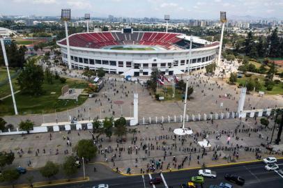 In this aerial view people queue to cast their ballot in a constitutional referendum voting at a polling station in the National Stadium of Santiago, on October 25, 2020. - A year to the day after more than one million people thronged downtown Santiago in the biggest march of Chiles social uprising, Chileans vote Sunday on whether to change the countrys dictatorship-era constitution. (Photo by JAVIER TORRES / AFP)<!-- NICAID(14625542) -->