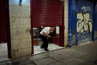 An employee prepares to close a bar at the end of a days work at Plaza Mayor in Madrid on October 24, 2020. - Spain is bracing for a new national state of emergency to allow the imposition of curfews as its regions pushed for action to slow surging virus cases. (Photo by OSCAR DEL POZO / AFP)<!-- NICAID(14625967) -->