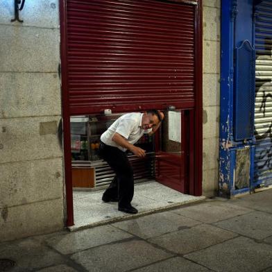 An employee prepares to close a bar at the end of a days work at Plaza Mayor in Madrid on October 24, 2020. - Spain is bracing for a new national state of emergency to allow the imposition of curfews as its regions pushed for action to slow surging virus cases. (Photo by OSCAR DEL POZO / AFP)<!-- NICAID(14625967) -->