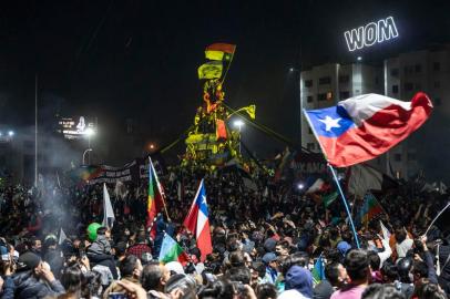 Demonstrators supporting the reform of the Chilean constitution celebrate the referendum official results at Plaza Italia square in Santiago on October 25, 2020. - Chiles President Sebastian Pinera called on the nation to work together for a new constitution after Chileans voted overwhelmingly to replace their dictatorship-era charter. (Photo by Pedro Ugarte / AFP)<!-- NICAID(14626382) -->