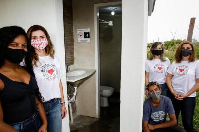  PORTO ALEGRE, RS, BRASIL, 23-10-2020: A vice-presidente da ONG Casarao, Stefany da Silva Santos, 25 anos, as voluntarias Daiane Kaminski, Jacqueline Alvorcem e Ana Paula Bampi e o morador Erick Miceli da Silva (agachado), 21, ao lado de um dos dois banheiros construidos pelo projeto social Fome de Que? para habitantes da Vila Casarao. Familias que moram na regiao nao tem banheiro em casa. (Foto: Mateus Bruxel / Agencia RBS)Indexador: Mateus Bruxel<!-- NICAID(14624323) -->