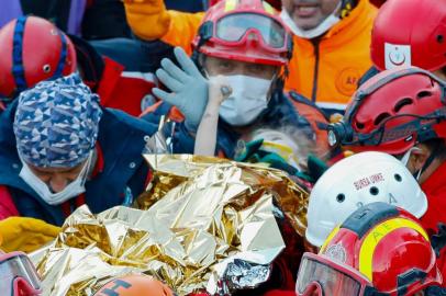 A handout picture taken and released on November 2, 2020 by Istanbul fire department shows Elif Perincek, a three-year-old survivor, holding the thumb of a rescue worker as she is carried out of a collapsed building after an earthquake in the Aegean port city of Izmir. - Rescue workers were searching eight buildings in Izmir despite dwindling hope for survivors, as the death toll of a powerful magnitude earthquake which hit western Turkey rose to 69. The 7.0-magnitude quake has also injured 896 in Turkey, the Turkish emergency authority AFAD said, after striking on October 30, afternoon near the west coast town of Seferihisar in Izmir province. (Photo by Serkan OKTAR / various sources / AFP) / RESTRICTED TO EDITORIAL USE - MANDATORY CREDIT AFP PHOTO /ISTANBUL FIRE DEPARTMENT/SERKAN OKTAR  - NO MARKETING - NO ADVERTISING CAMPAIGNS - DISTRIBUTED AS A SERVICE TO CLIENTS<!-- NICAID(14631885) -->