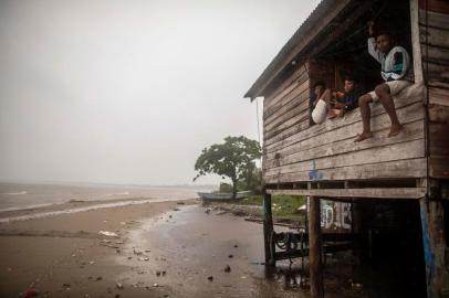 Children sit on a beach house window as Hurricane Eta approaches in Bilwi, Puerto Cabezas, Nicaragua, on November 2, 2020. - Eta rapidly intensified to a Category 4 hurricane on Monday as it bore down on the Caribbean coast of Nicaragua and Honduras, threatening the Central American countries with catastrophic winds and floods. (Photo by INTI OCON / AFP)<!-- NICAID(14632820) -->