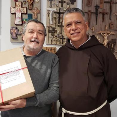 Frei Carlos Silva (direita), conselheiro geral da Ordem dos Frades Menores Capuchinhos, entrega o processo que investiga o suposto milagre atribuído ao frei Salvador Pizetta para o postulador geral, frei Carlo Calloni, em Roma<!-- NICAID(14641117) -->