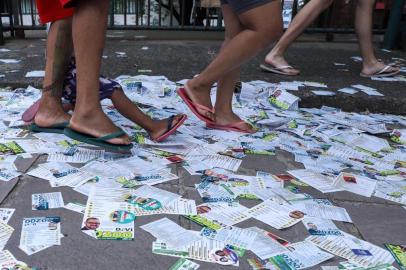  ** EM BAIXA** PORTO ALEGRE, RS, BRASIL - 15.11.2020 - Terceiro maior colégio de Porto Alegre tem calçada coberta de panfletos de candidatos. A calçada em frente a Escola Estadual de Ensino Médio Baltazar de Oliveira Garcia, no bairro Jardim Leopoldina, zona norte da Capital, amanheceu e permaneceu coberta de panfletos durante o domingo de votação. Os santinhos, visivelmente, eram em sua maioria de candidatos a vereador. Inúmeros partidos, de vertentes distintas, foram identificados nos materiais de propaganda. Na imagem, Calçada da escola Baltazar de Oliveira Garcia, no bairro Leopoldina. No detalhe, uma criança escorrega nos santinhos e cai. (Foto: Isadora Neumann/Agencia RBS<!-- NICAID(14643662) -->