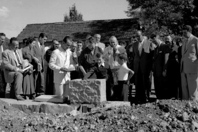 Solenidade de lançamento da pedra fundamental do Hospital Fátima, atual Hospital Virvi Ramos, em 12 de março de 1955, no terreno do bairro Madureira. Vê-se, de terno branco com a pedra na mão, o engenheiro Romano Lunardi. A partir da esquerda, o médico Rubens Ramos, um senhor não identificado (com o pé na pedra), Zilá Spinato Ribeiro, José Ribeiro, um frei capuchinho, a senhora Luiza Ronca, a esposa do senhor Julio Rosa Cruz (mulher de óculos), Clelia Spinato Manfro, um senhor não identificado atrás, Dom Benedito Zorzi, os meninos Virgilio Ramos e Dirceu Ramos (filhos de Virvi Ramos), o prefeito Hermes João Webber, o casal Giovani Scavino e Maria Elisa Eberle, o médico Virvi Ramos, um frei e um senhor não identificado.<!-- NICAID(14648640) -->