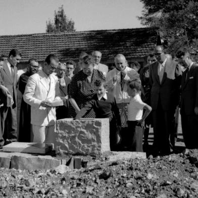 Solenidade de lançamento da pedra fundamental do Hospital Fátima, atual Hospital Virvi Ramos, em 12 de março de 1955, no terreno do bairro Madureira. Vê-se, de terno branco com a pedra na mão, o engenheiro Romano Lunardi. A partir da esquerda, o médico Rubens Ramos, um senhor não identificado (com o pé na pedra), Zilá Spinato Ribeiro, José Ribeiro, um frei capuchinho, a senhora Luiza Ronca, a esposa do senhor Julio Rosa Cruz (mulher de óculos), Clelia Spinato Manfro, um senhor não identificado atrás, Dom Benedito Zorzi, os meninos Virgilio Ramos e Dirceu Ramos (filhos de Virvi Ramos), o prefeito Hermes João Webber, o casal Giovani Scavino e Maria Elisa Eberle, o médico Virvi Ramos, um frei e um senhor não identificado.<!-- NICAID(14648640) -->