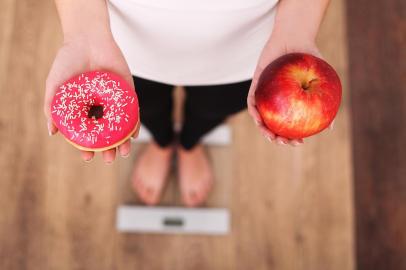 Diet. Woman Measuring Body Weight On Weighing Scale Holding Donut and apple. Sweets Are Unhealthy Junk Food. Dieting, Healthy Eating, Lifestyle. Weight Loss. Obesity. Top ViewDiet. Woman Measuring Body Weight On Weighing Scale Holding Donut and apple. Sweets Are Unhealthy Junk Food. Dieting, Healthy Eating, Lifestyle. Weight Loss. Obesity. Top ViewFonte: 131800908<!-- NICAID(14646767) -->